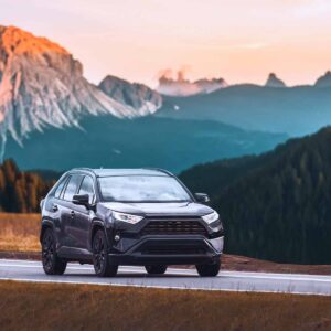 Car driving with mountains in the background at sunrise