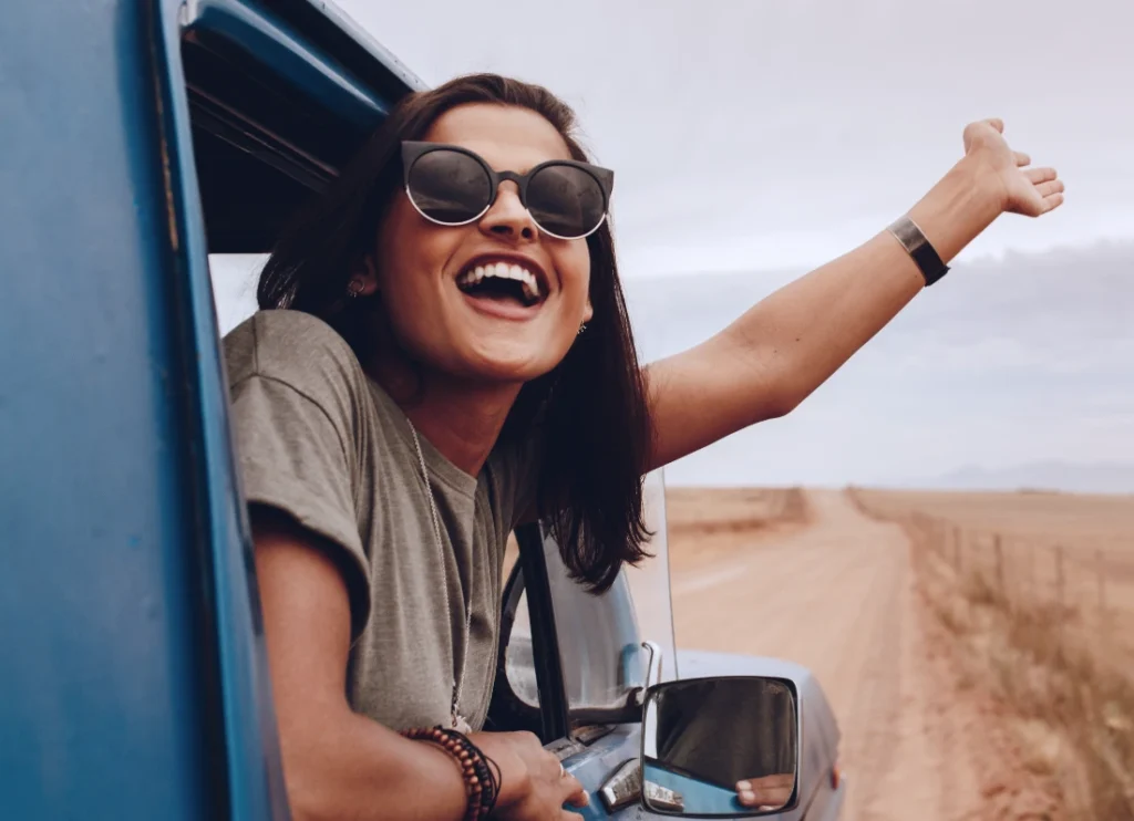 Woman leaning out of a car window smiling