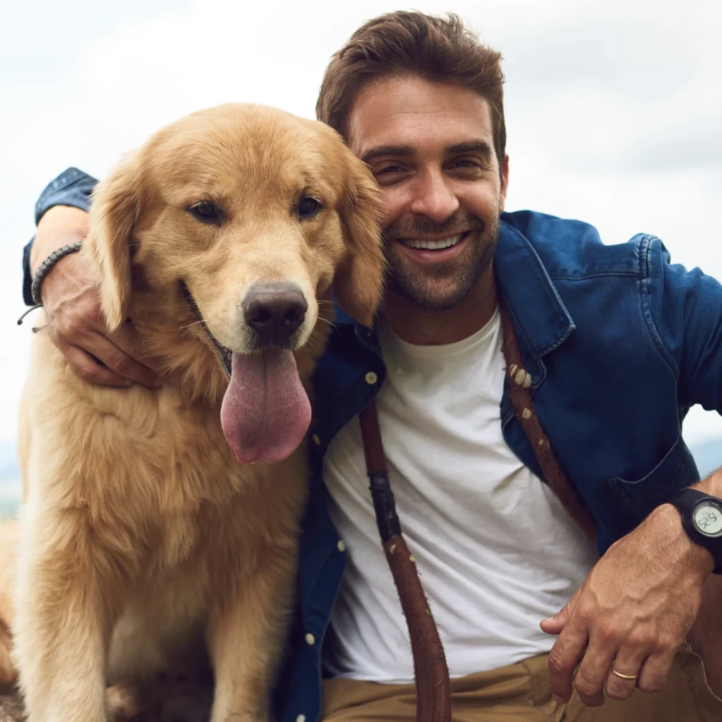 Man smiling with his dog outdoors