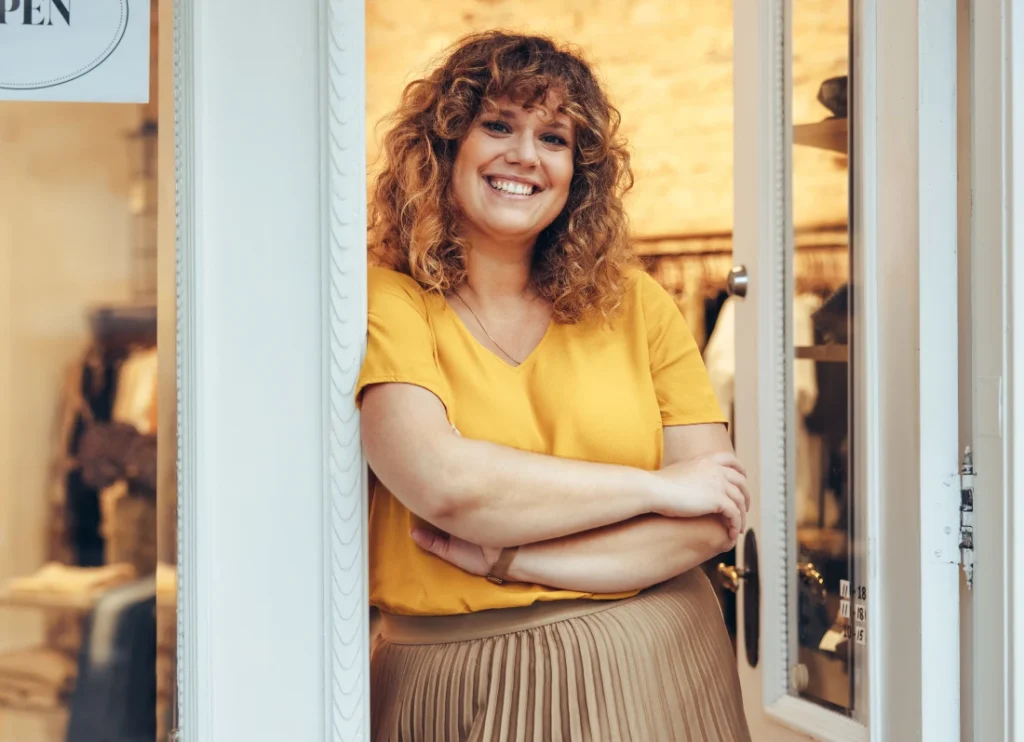 Small business owner smiling in doorway