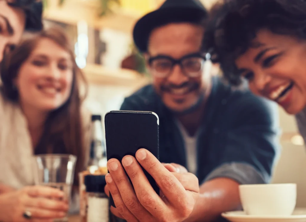 Friends smiling and looking at a phone together