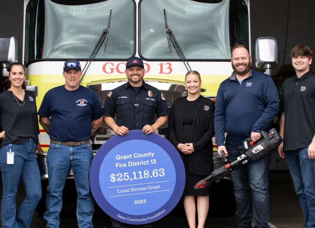 Firefighters and community members posing with a donation check